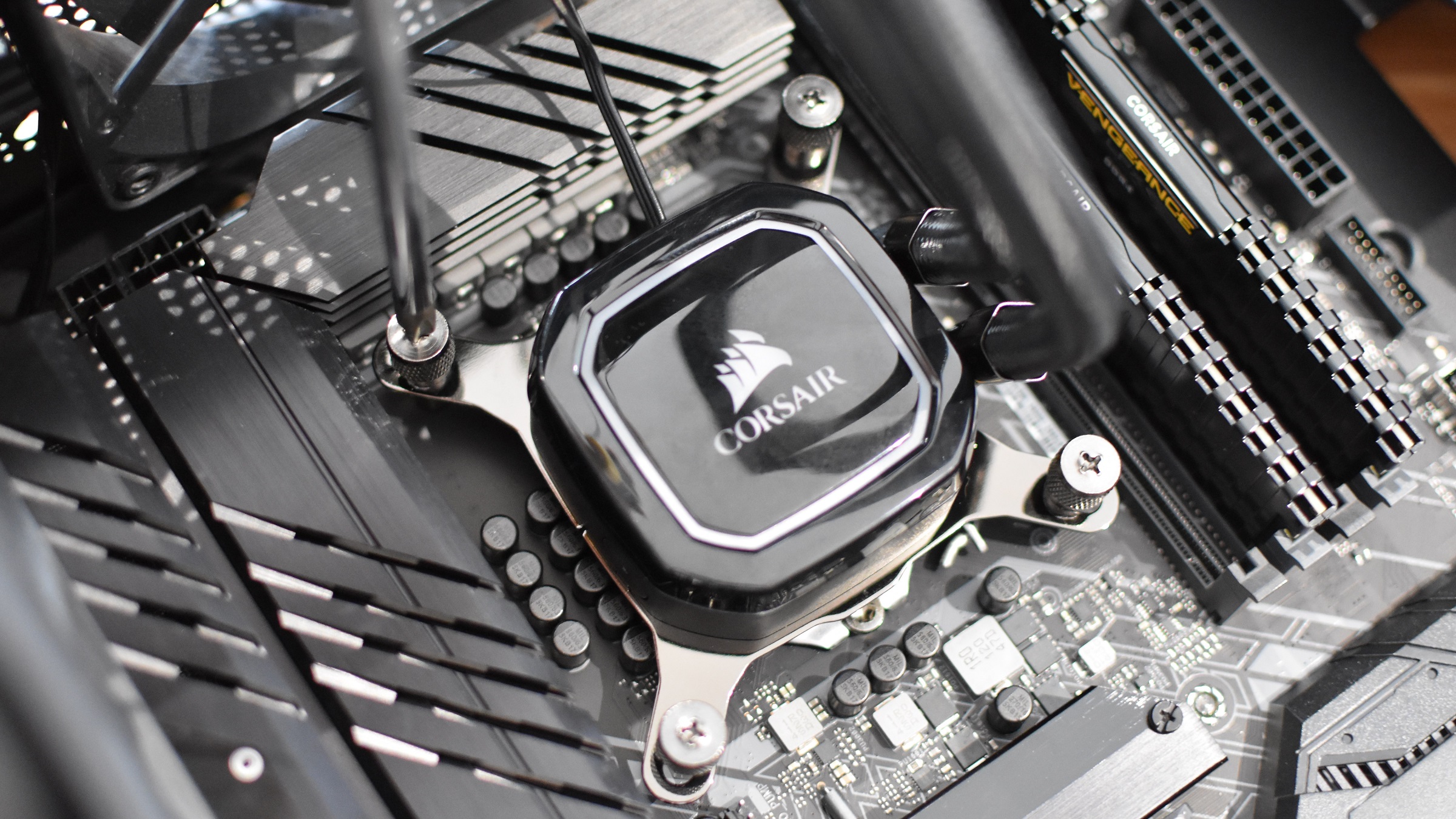 The pump of a Corsair AIO watercooler being installed on a motherboard.