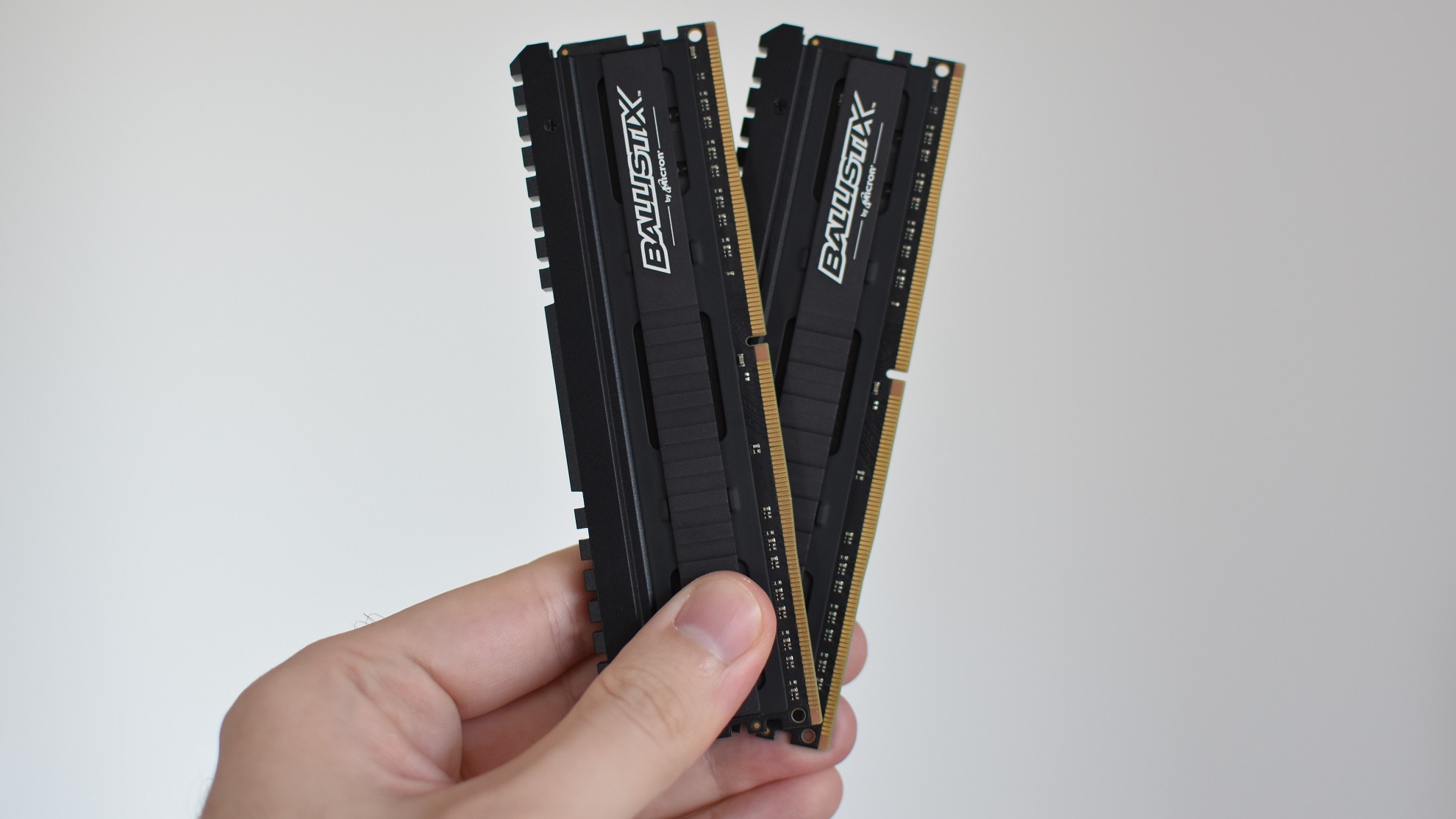 Two sticks of DDR4 RAM being held in a hand.