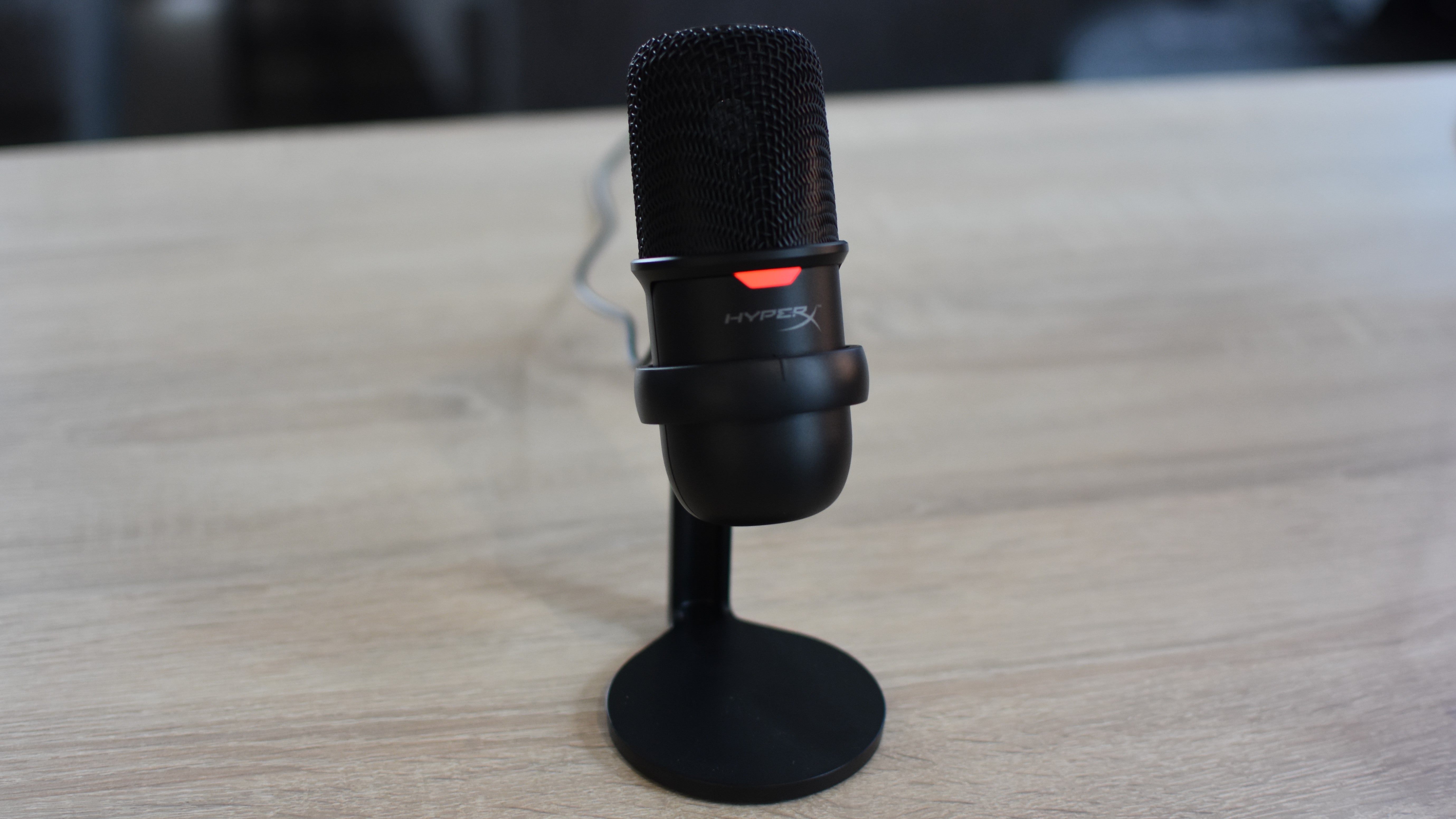 The HyperX SoloCast microphone on a desk.