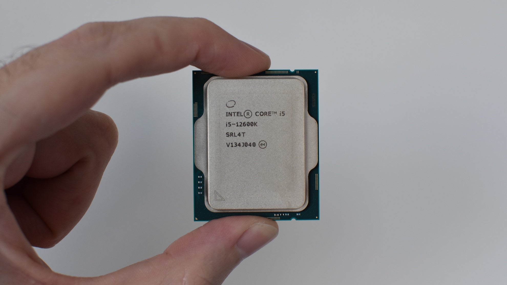 An Intel Core i5-12600K CPU being held between a finger and thumb.