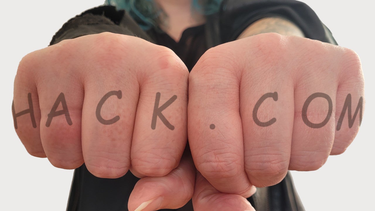 Outstretched fists displaying a mock-up knuckle tattoo: HACK.COM