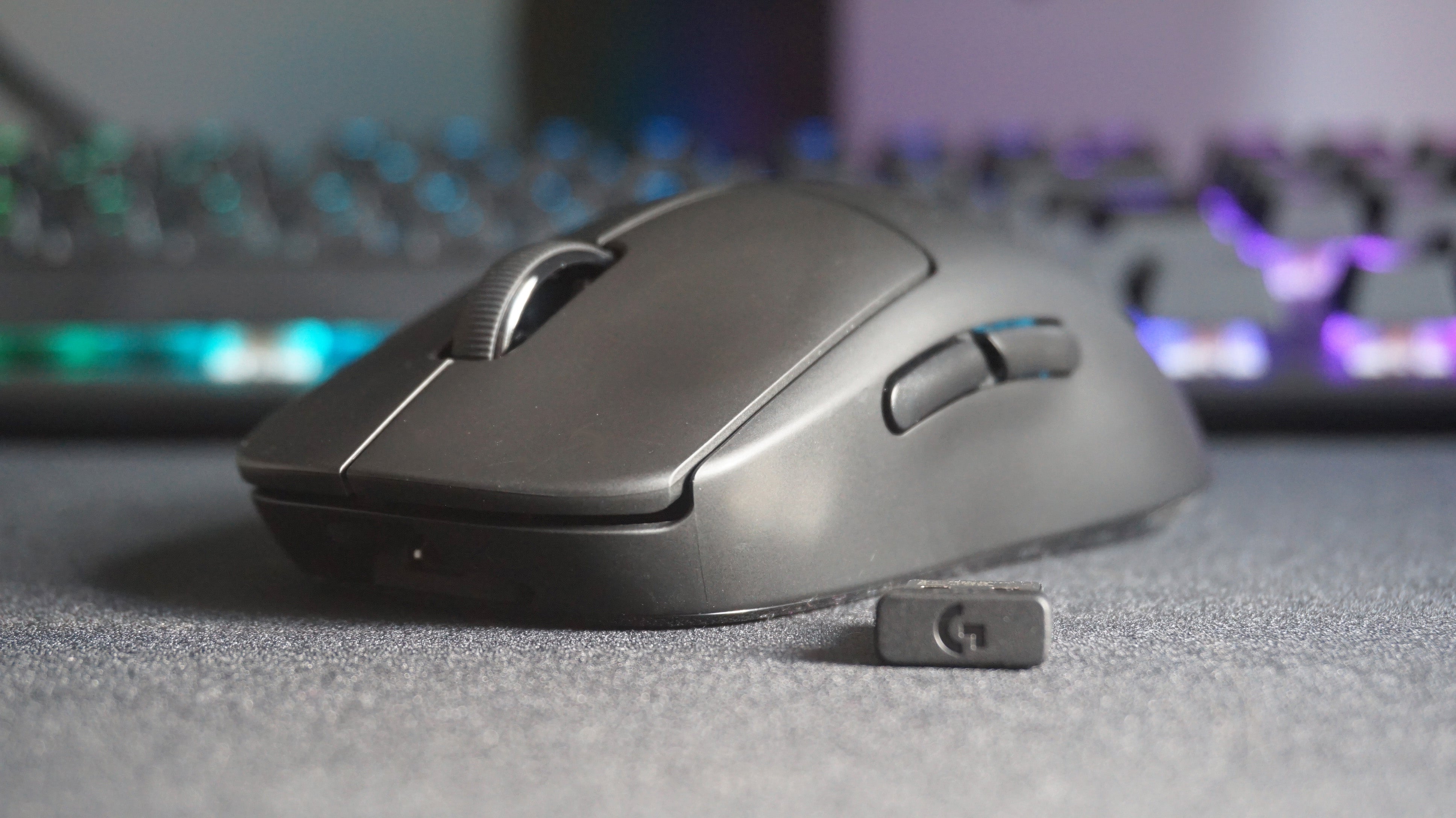 Фотография беспроводной мыши Logitech G Pro Wireless и ее USB-адаптера.