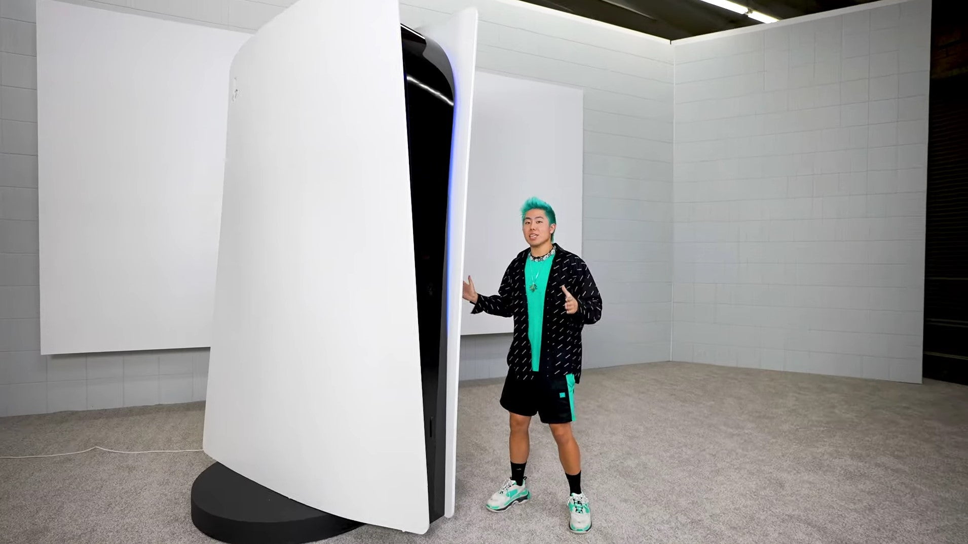 A man stands next to a 10ft tall PlayStation 5