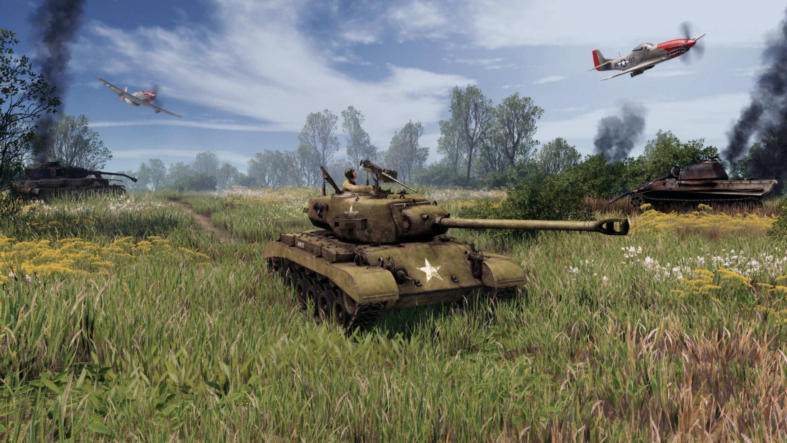 A Pershing tank rolls through a grassy field with planes overhead in Men Of War 2