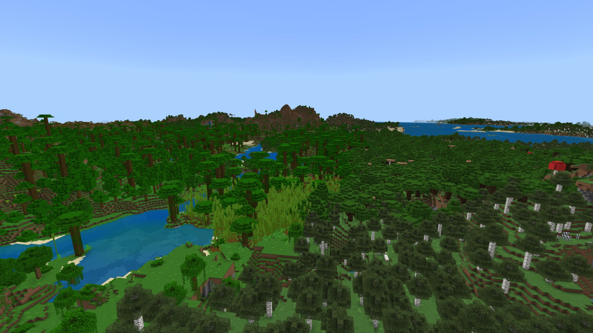 A forest-covered Minecraft Bedrock landscape, with the jungle on the left, the birch forest on the right, and the mountains in the background.
