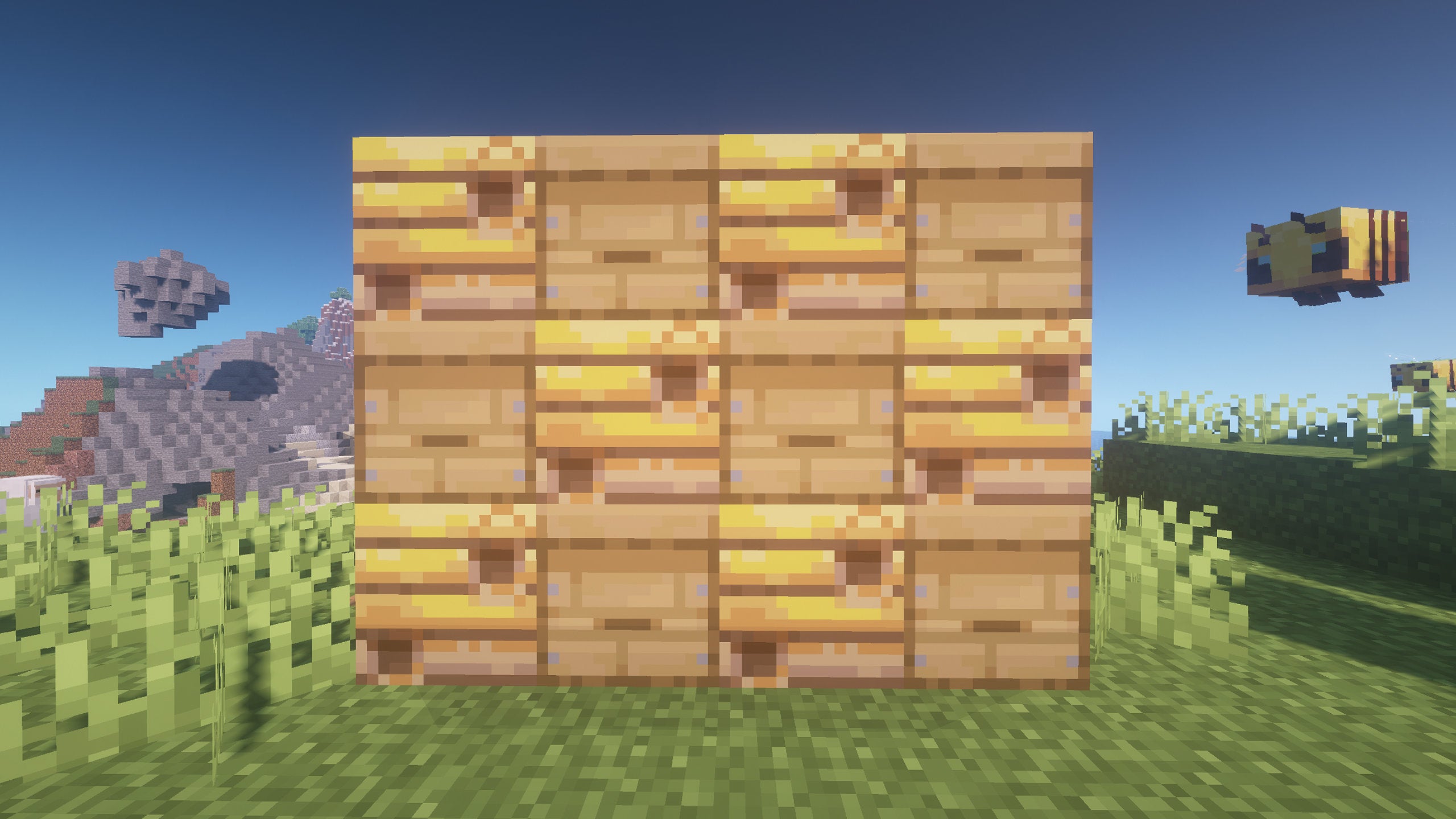 A 4x3 grid of Beehives and Bee Nests in Minecraft with a Bee flying around to the right of the grid of blocks.