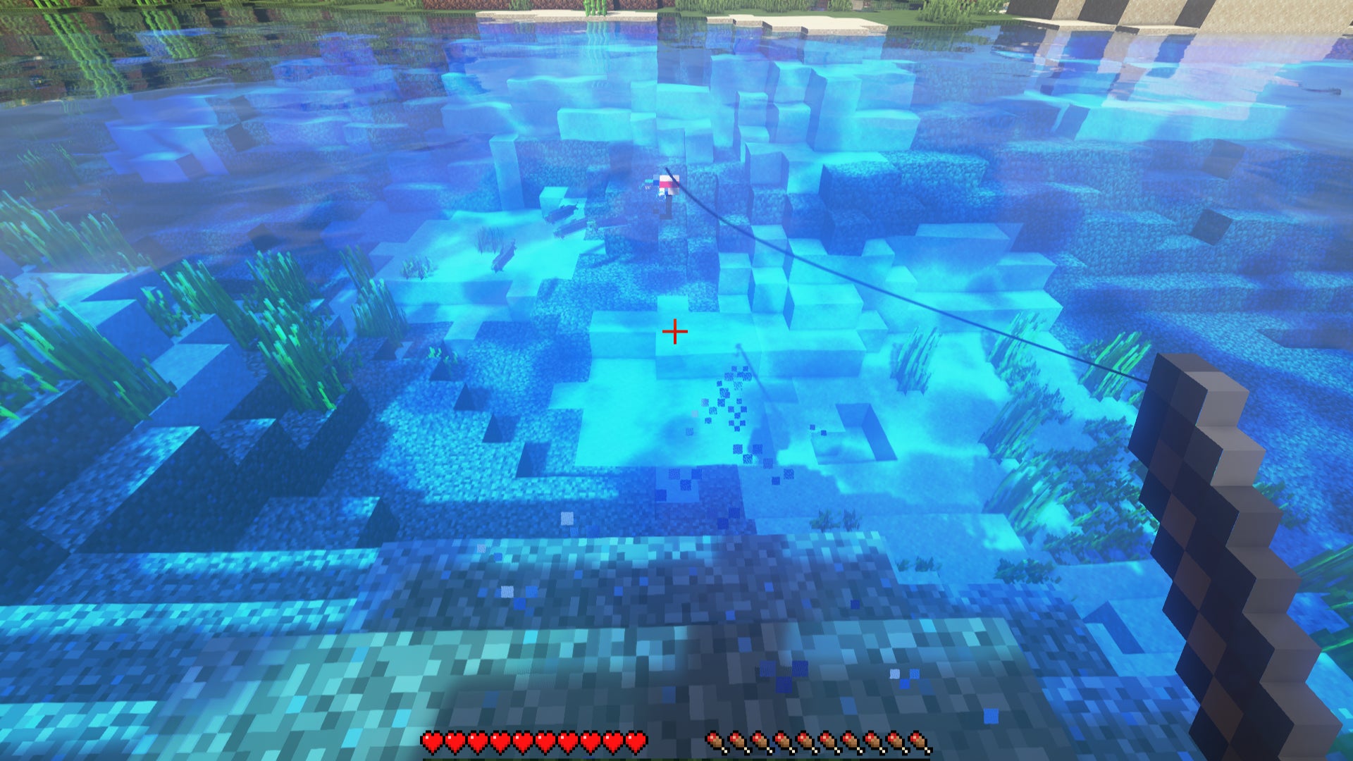 A player in Minecraft is fishing in a lake.  Between the bobber and the player, a V-shaped set of particles indicates the presence of a fish.