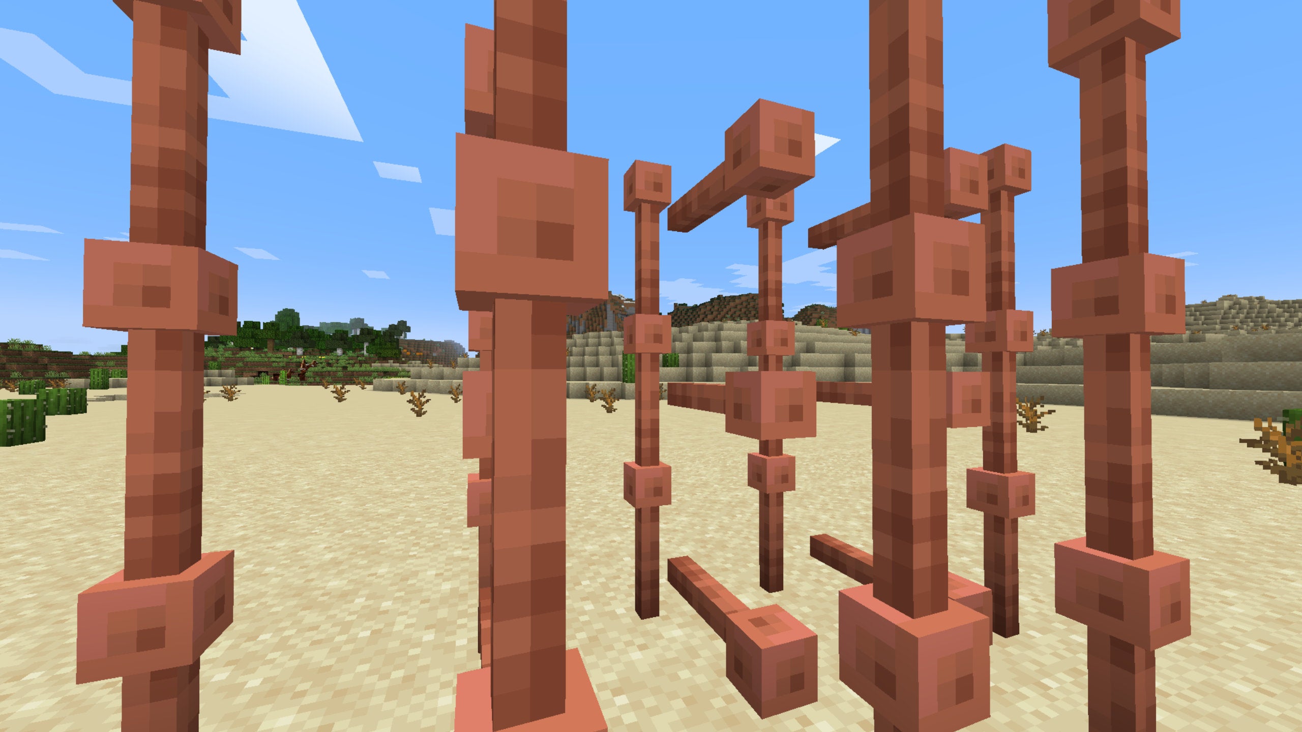 A Minecraft screenshot of several Lightning Rods organised in a shamefully impractical manner in the middle of a desert.