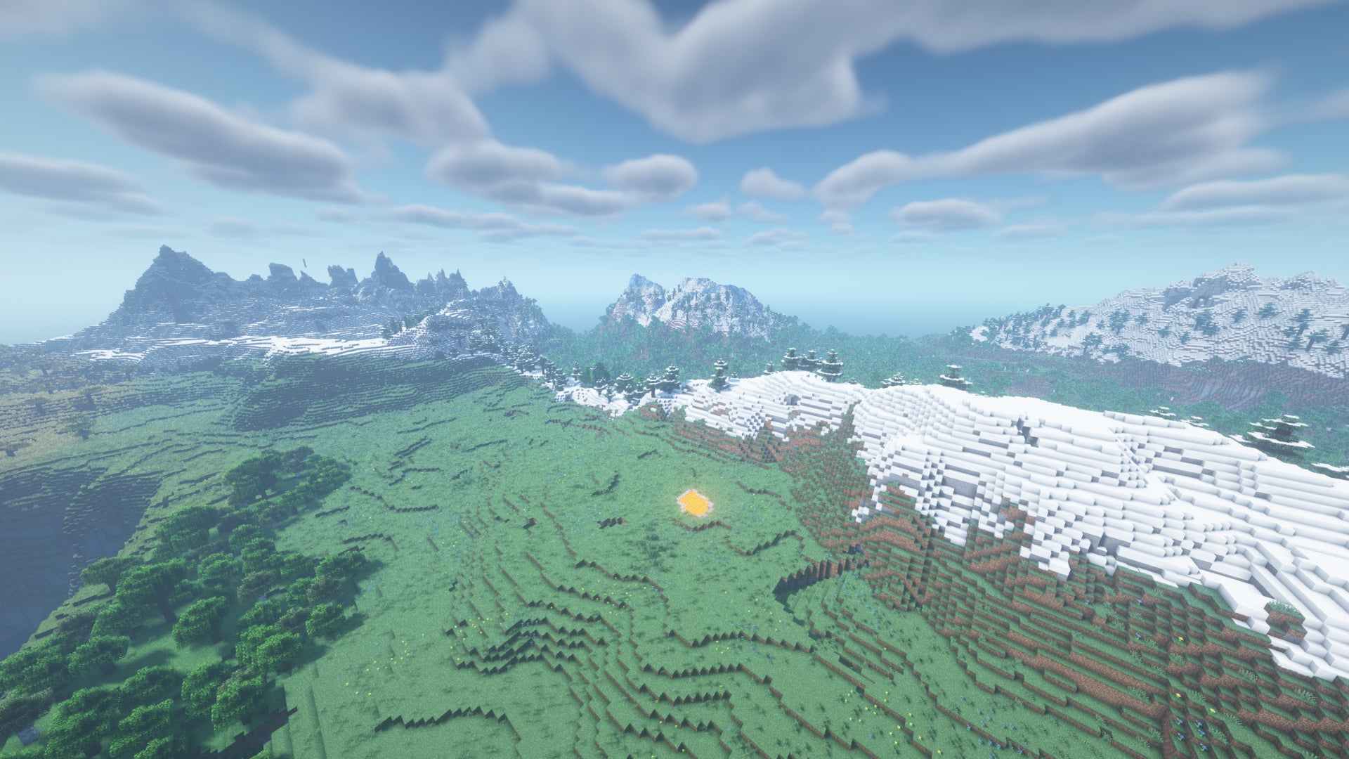 Un paysage Minecraft de plaines et d'arbres, avec des montagnes enneigées au loin.