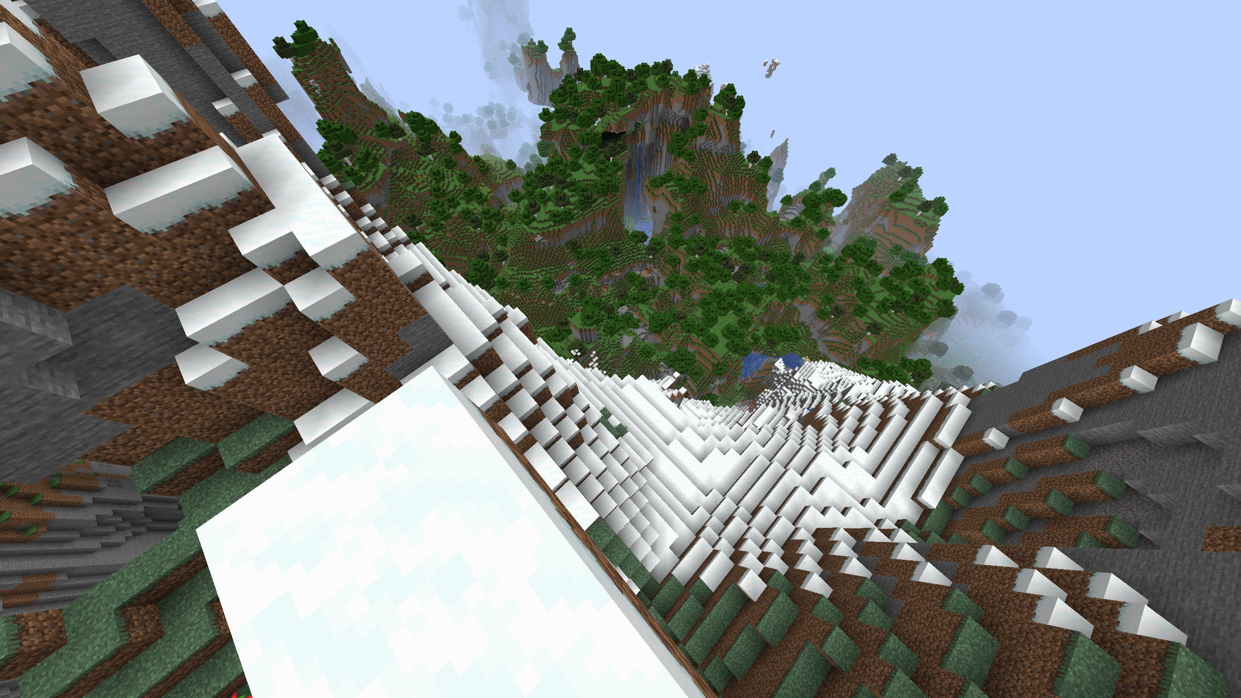 Mirando hacia abajo desde la cima de una montaña nevada muy alta en Minecraft.
