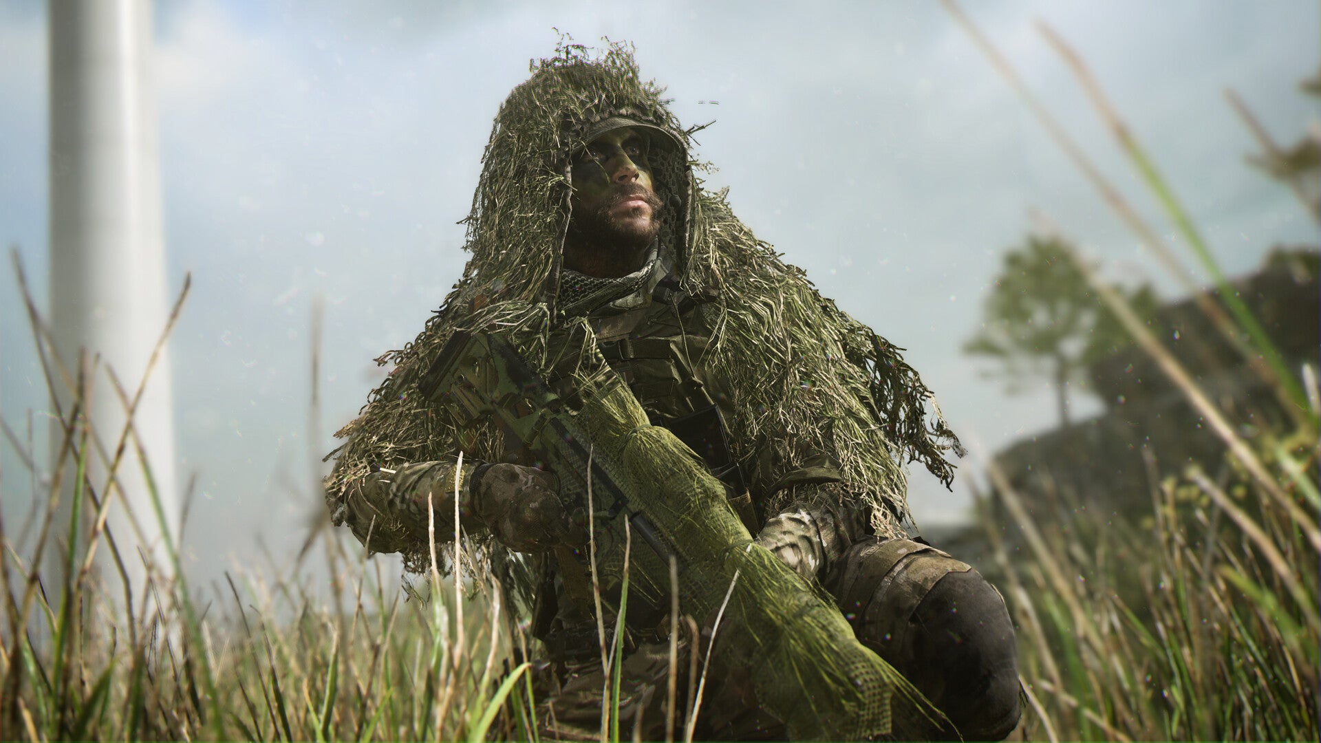 A soldier in camouflage crouches in a field holding a rifle in Modern Warfare 2.