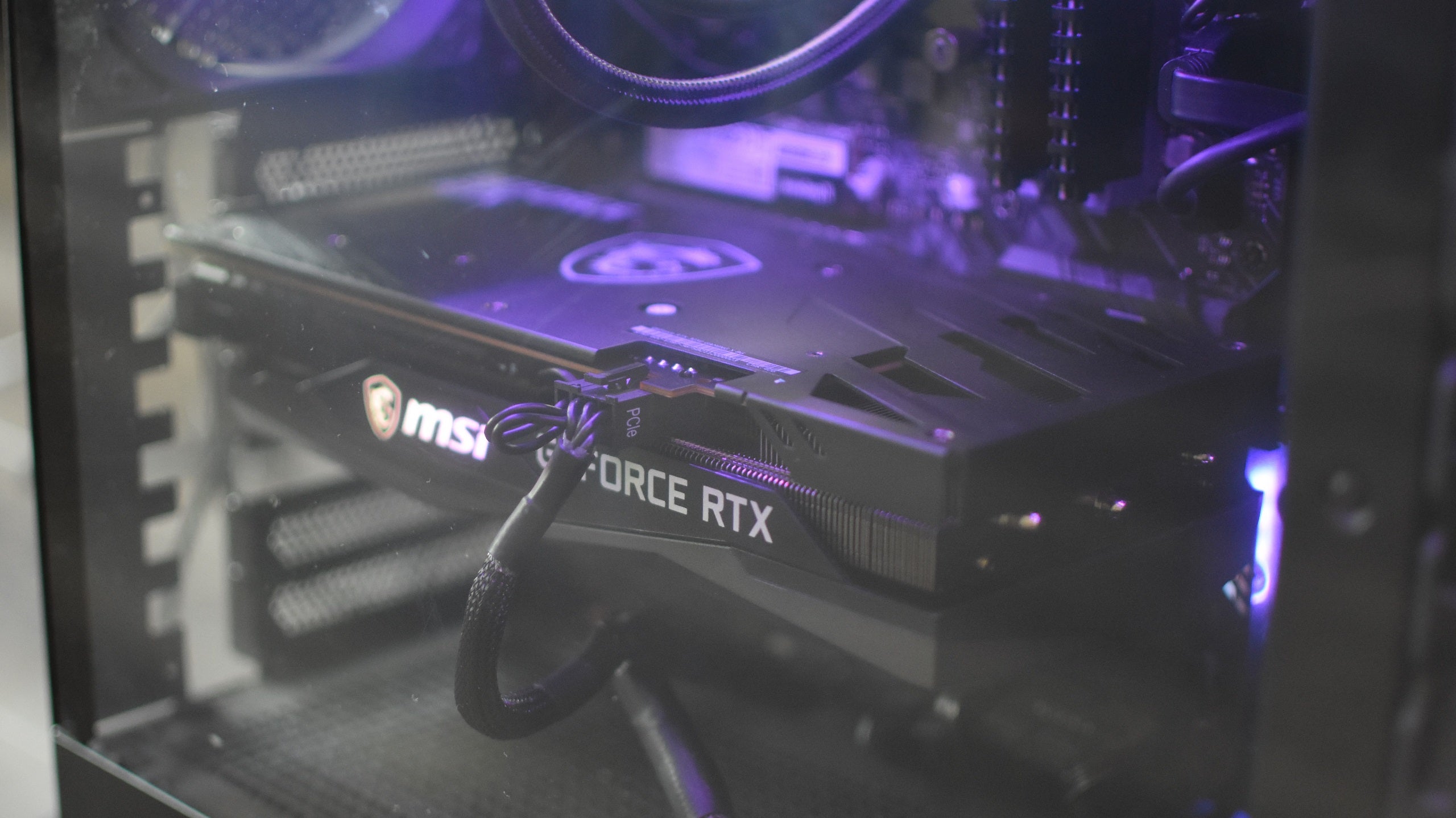 tHE MSI GeForce RTX 3060 Gaming X Trio behind the glass panel of a PC case.