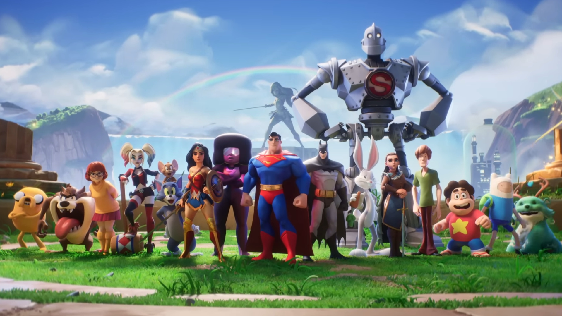 The original MultiVersus line-up pose in a row against an outdoor stage. From L-R: Jake the Dog, Taz, Velma, Harley Quinn, Tom and Jerry, Wonder Woman, Garnet, Superman, The Iron Giant, Bugs Bunny, Arya Stark, Shaggy, Steven Universe, Finn the Human, and Reindog.