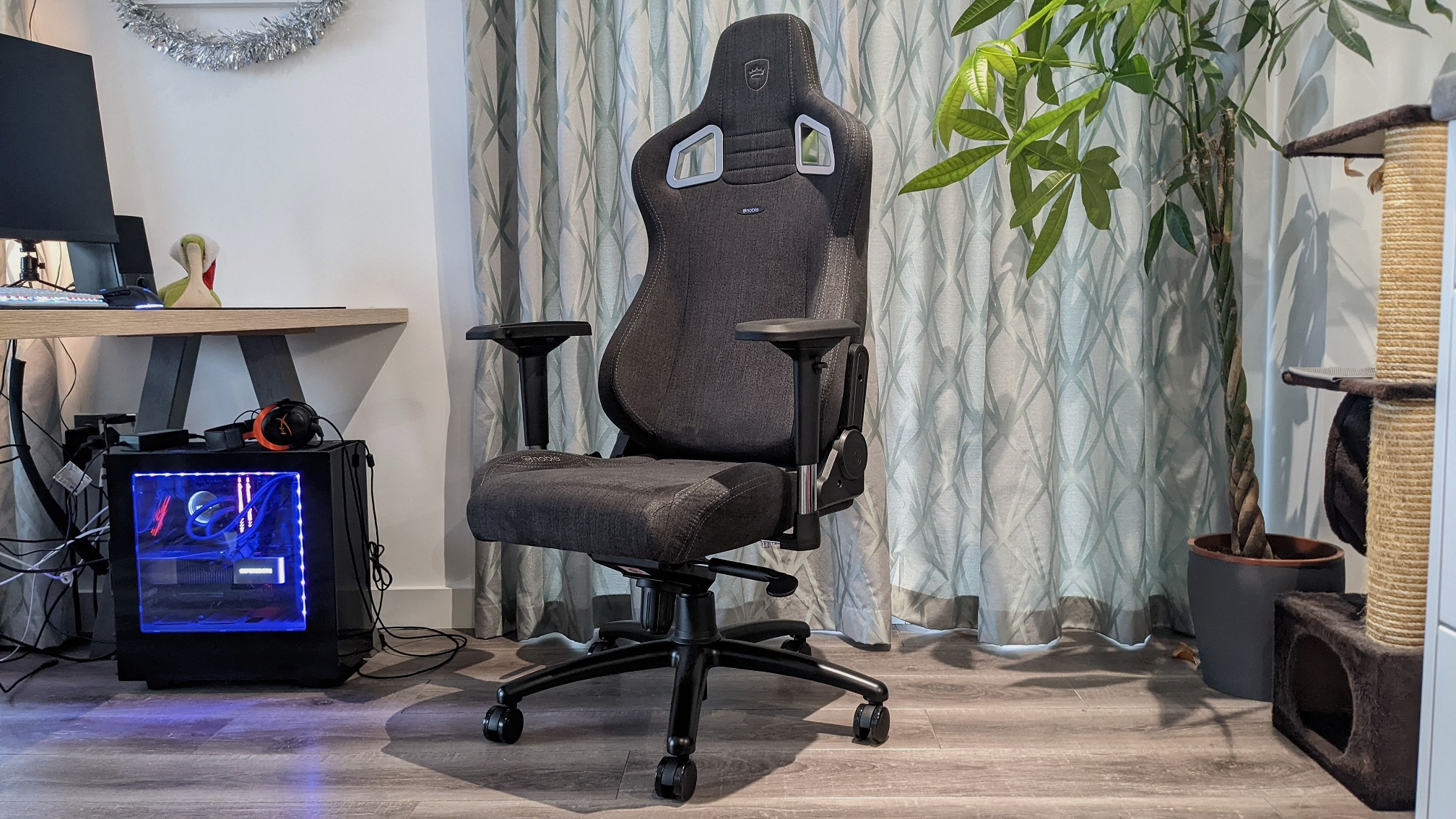 The Noblechairs Epic TX gaming chair, next to a desk.
