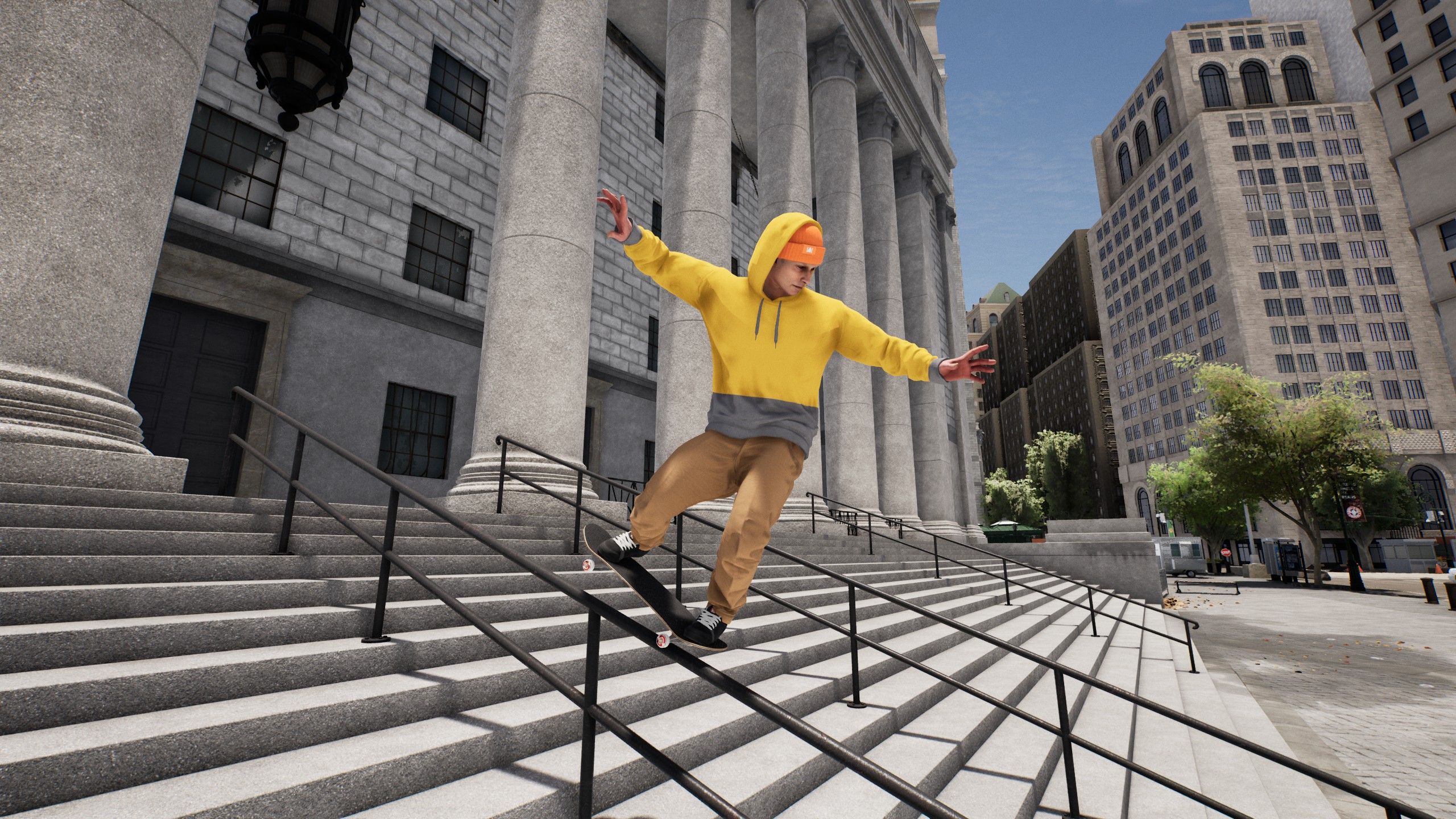 A skater in a yellow hoodie grinds down a stair rail in Session