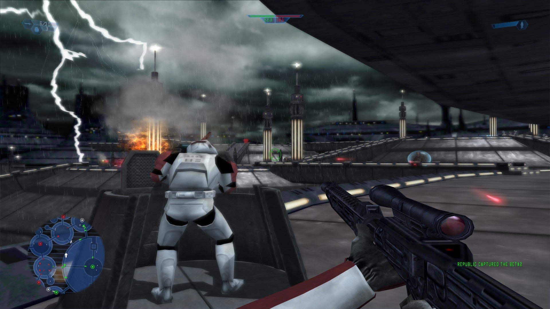 The player stands behind a stormtrooper in a stormy battle scene in Star Wars: Battlefront 2004