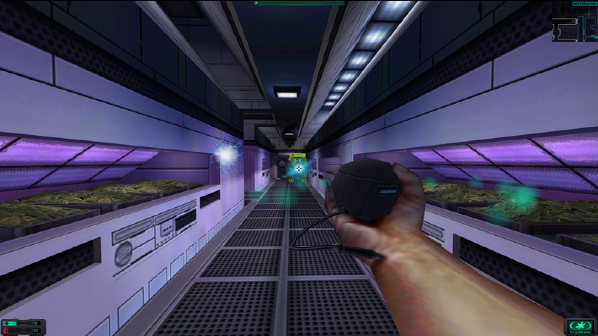 The player holds out their hand in a sci-fi corridor in System Shock 2