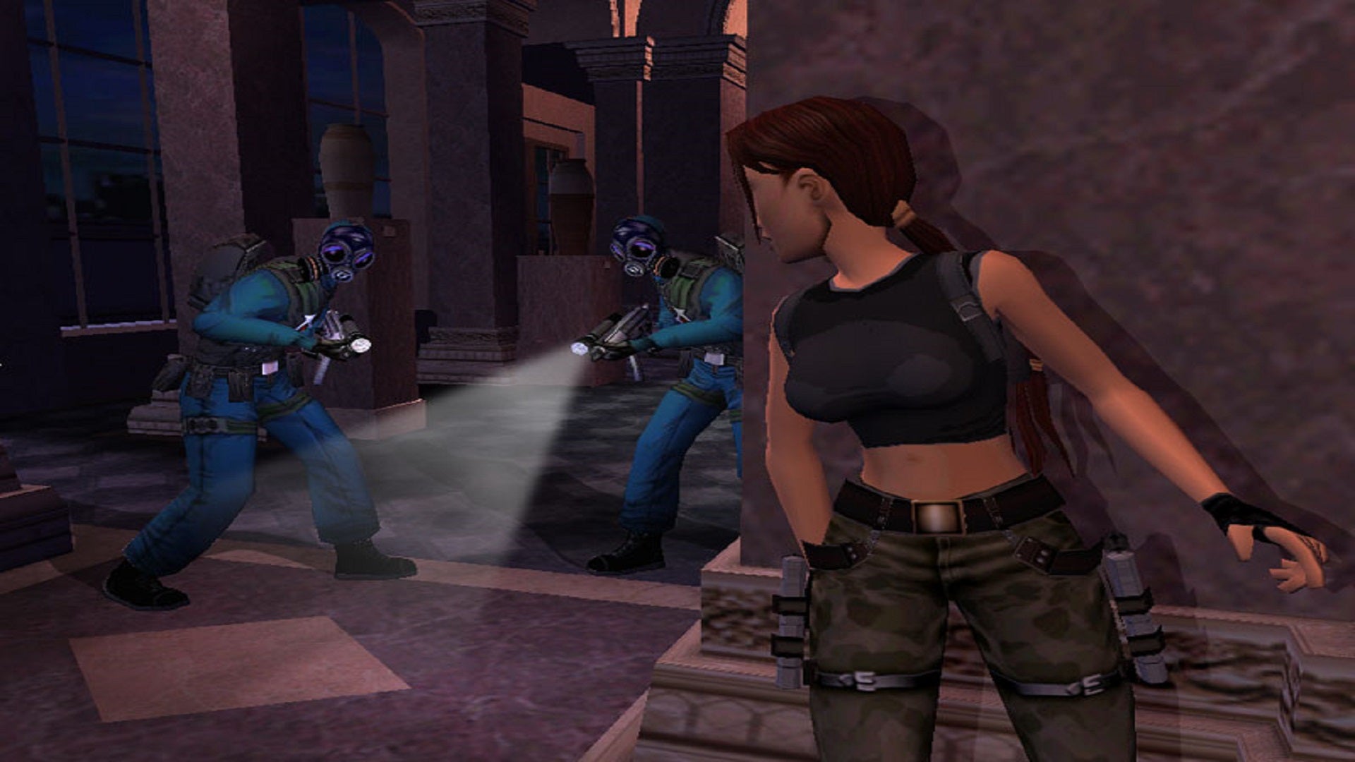 Lara Croft hides behind a wall in the Louvre as she is pursued by armed police.