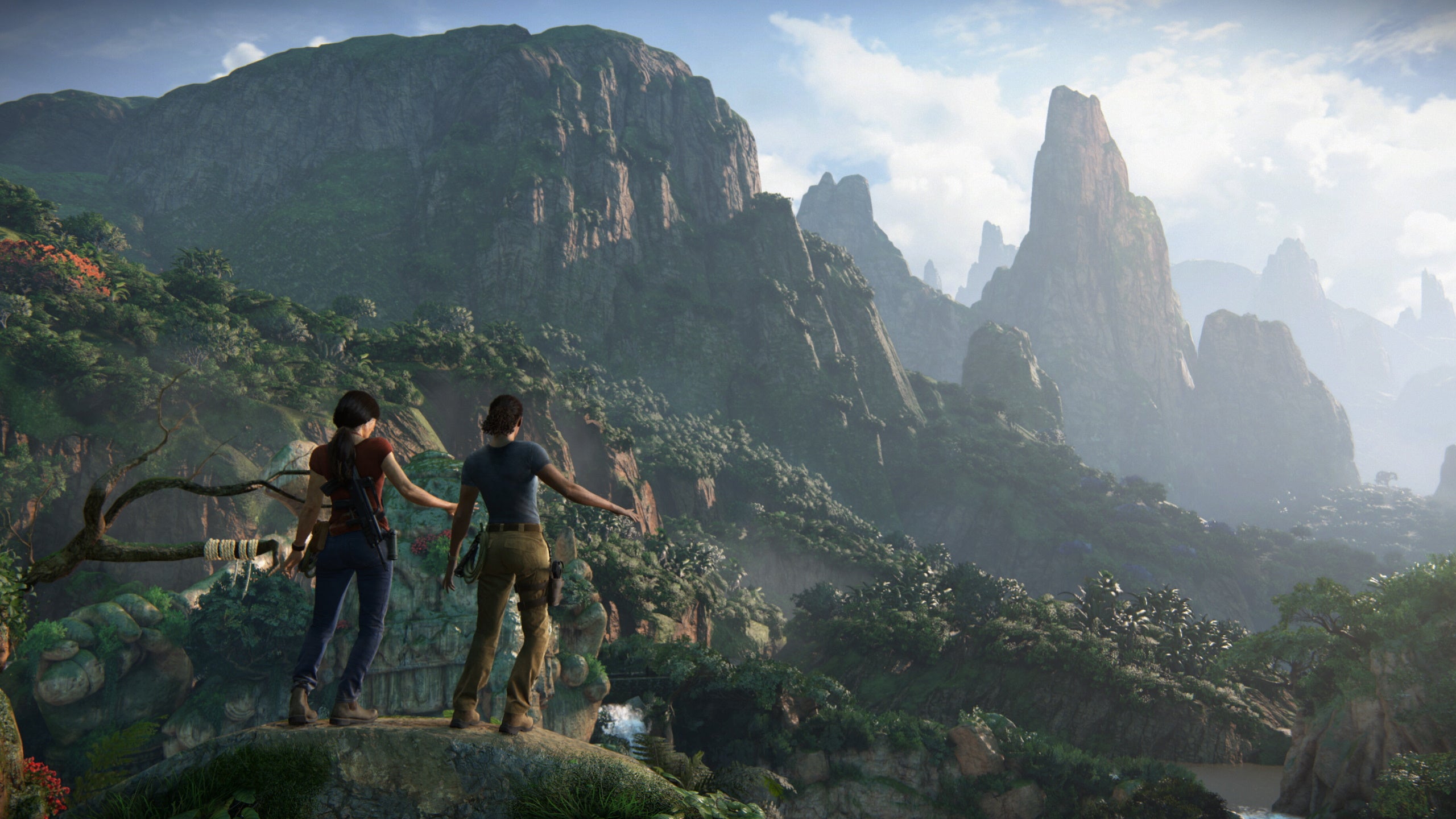 Two women stands on a large vine looking out over a mountainous landscape in Uncharted: Lost Legacy