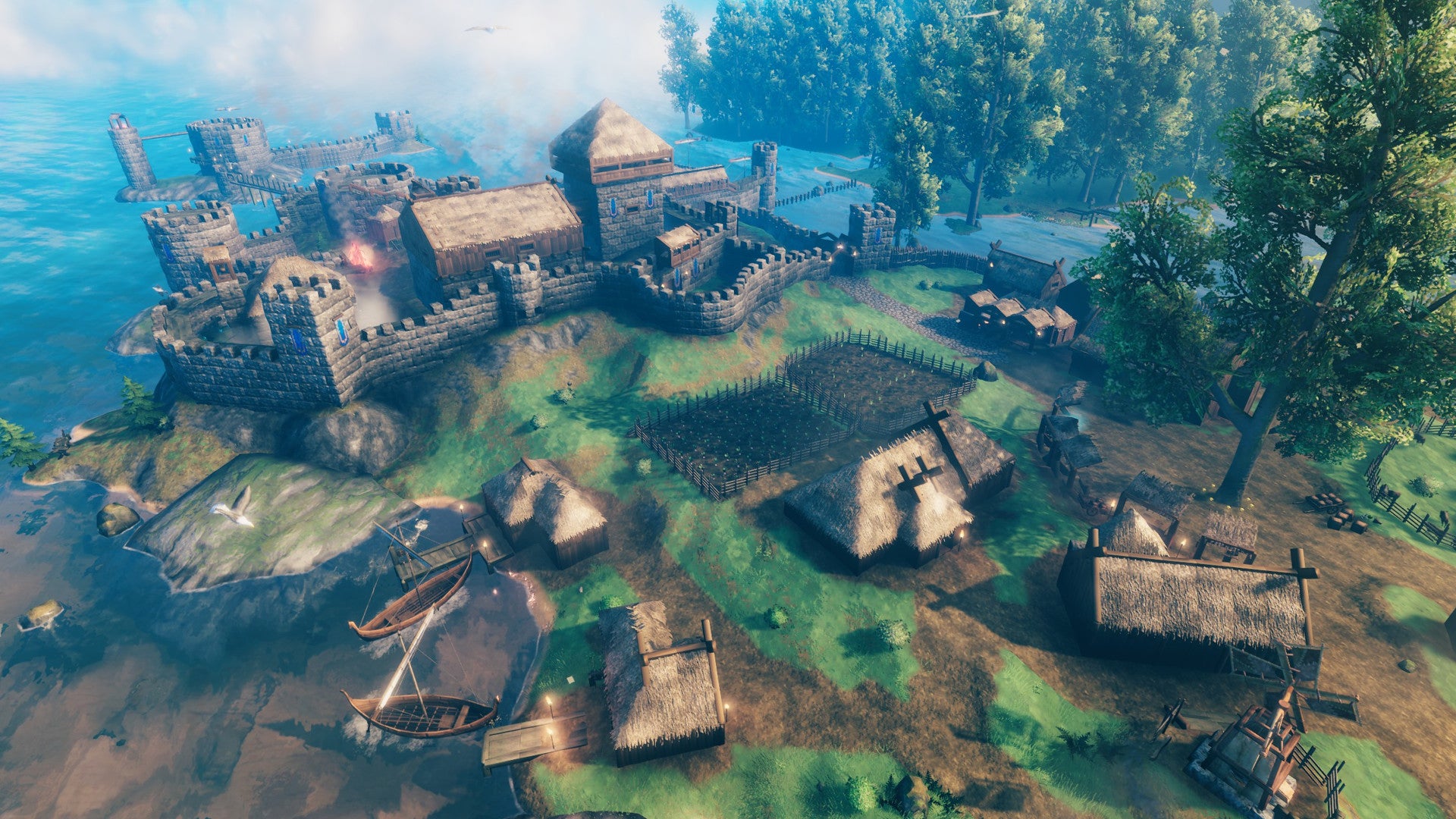A Valheim screenshot of an extensive settlement with multiple houses, walls, and farms, seen from an aerial perspective.