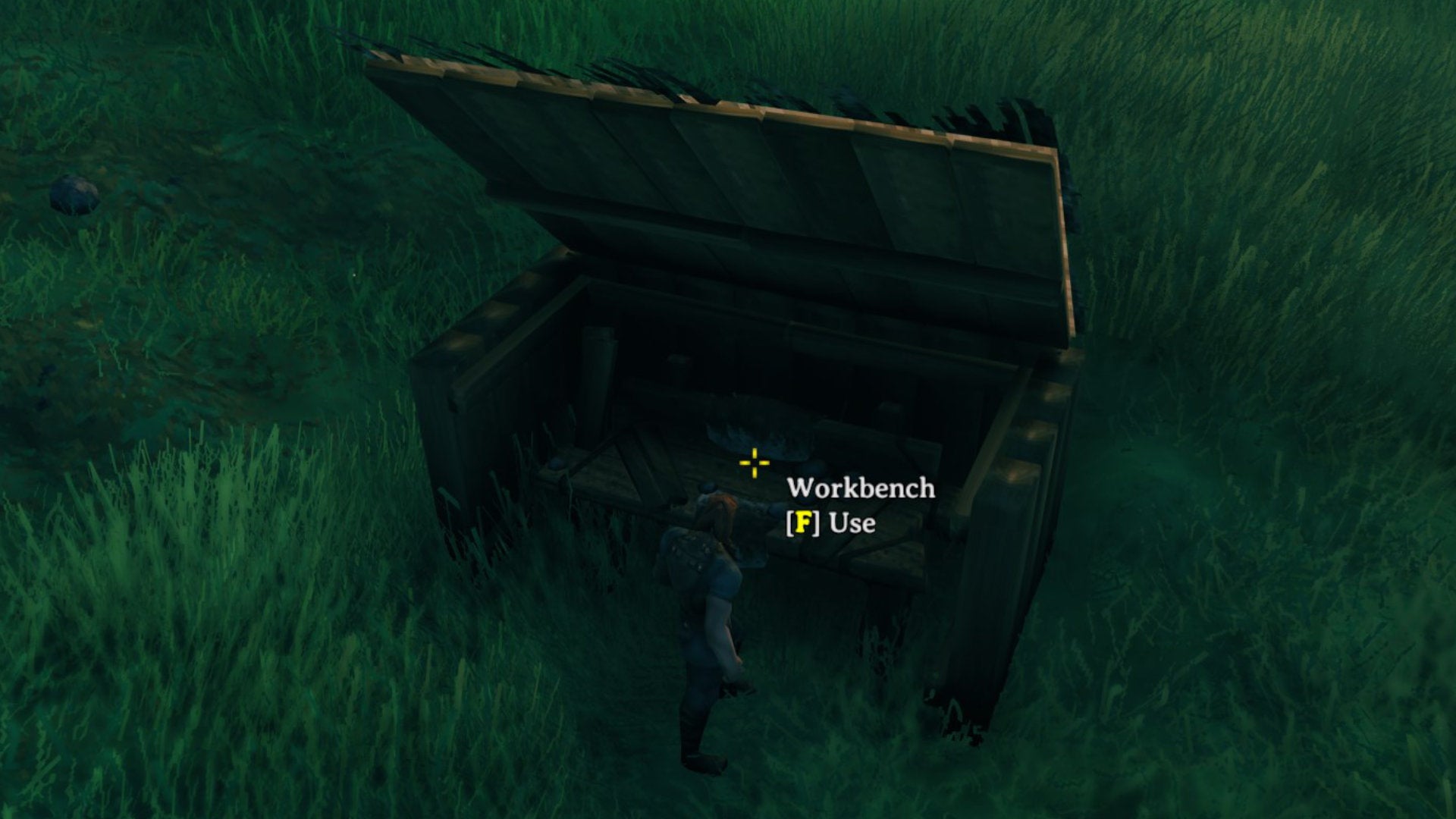 A Valheim screenshot of a Workbench surrounded by four wooden walls and topped with two roof tiles.