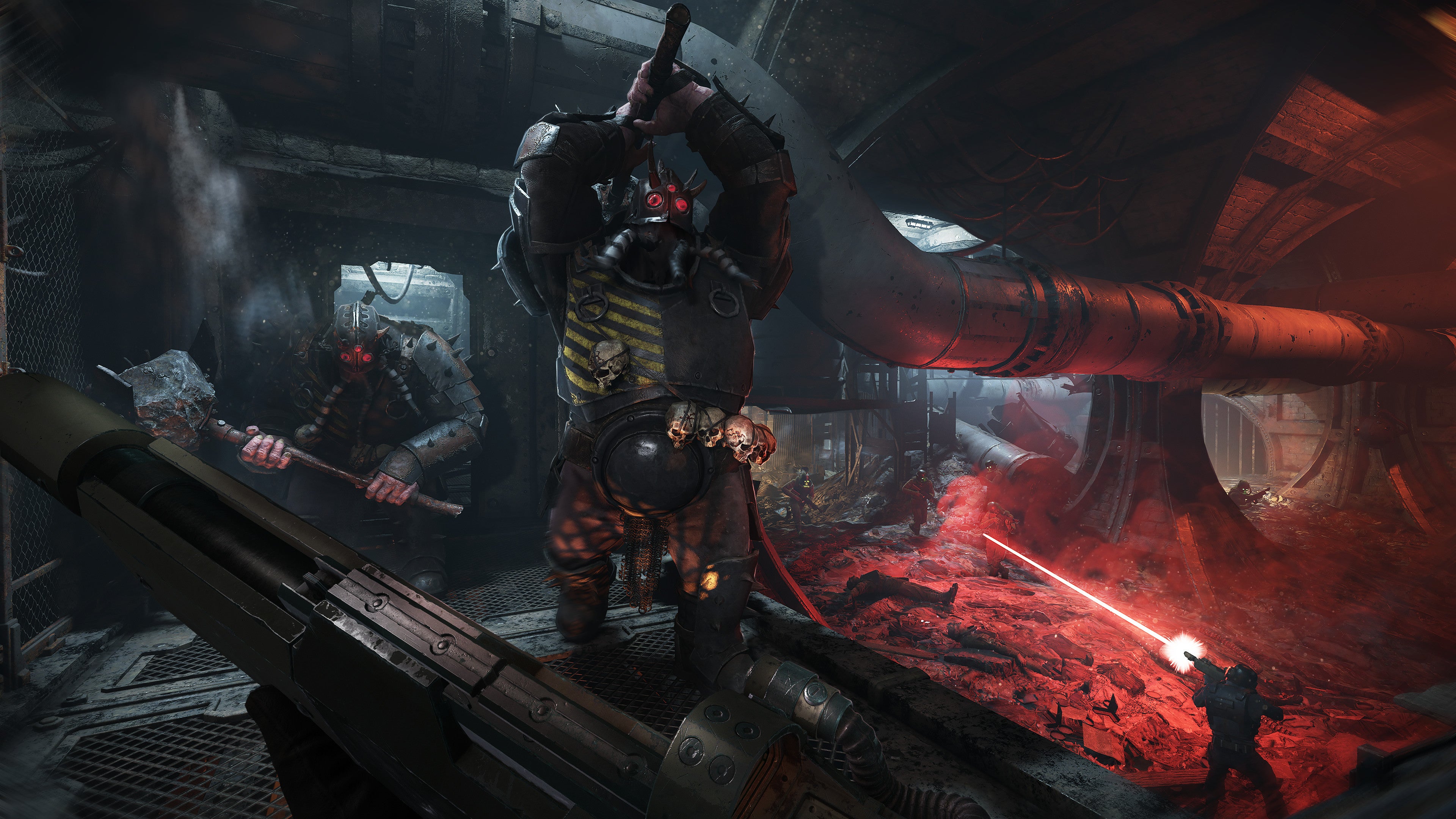 Burly men raise weaponry in a dark corridor in Warhammer 40K: Darktide.