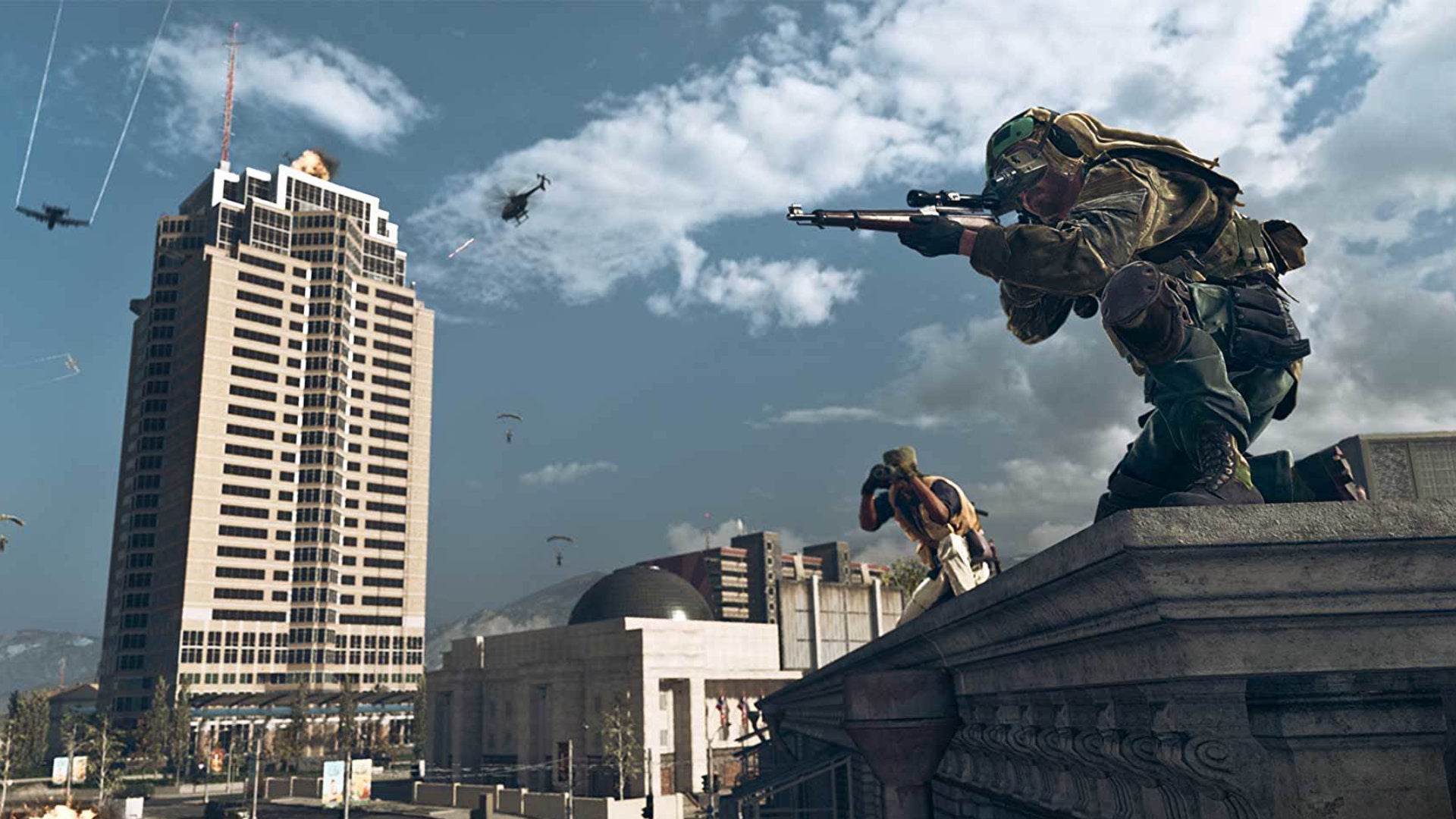 Two players in Warzone on a rooftop scouting for enemies.