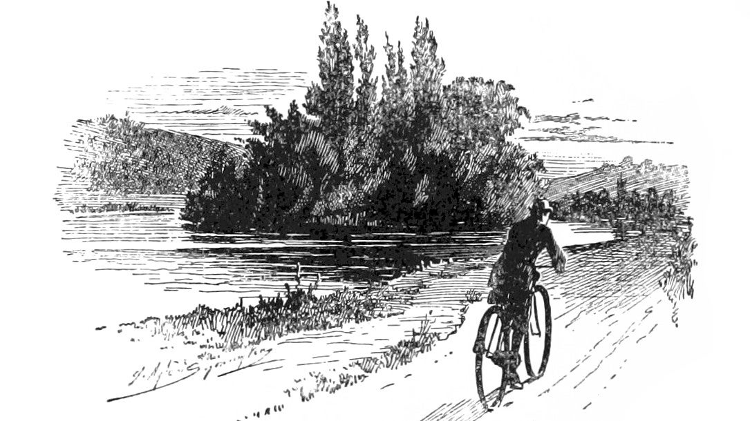 A cyclist rides alongside water in an illustration from 'The wheels of chance: a holiday adventure'.