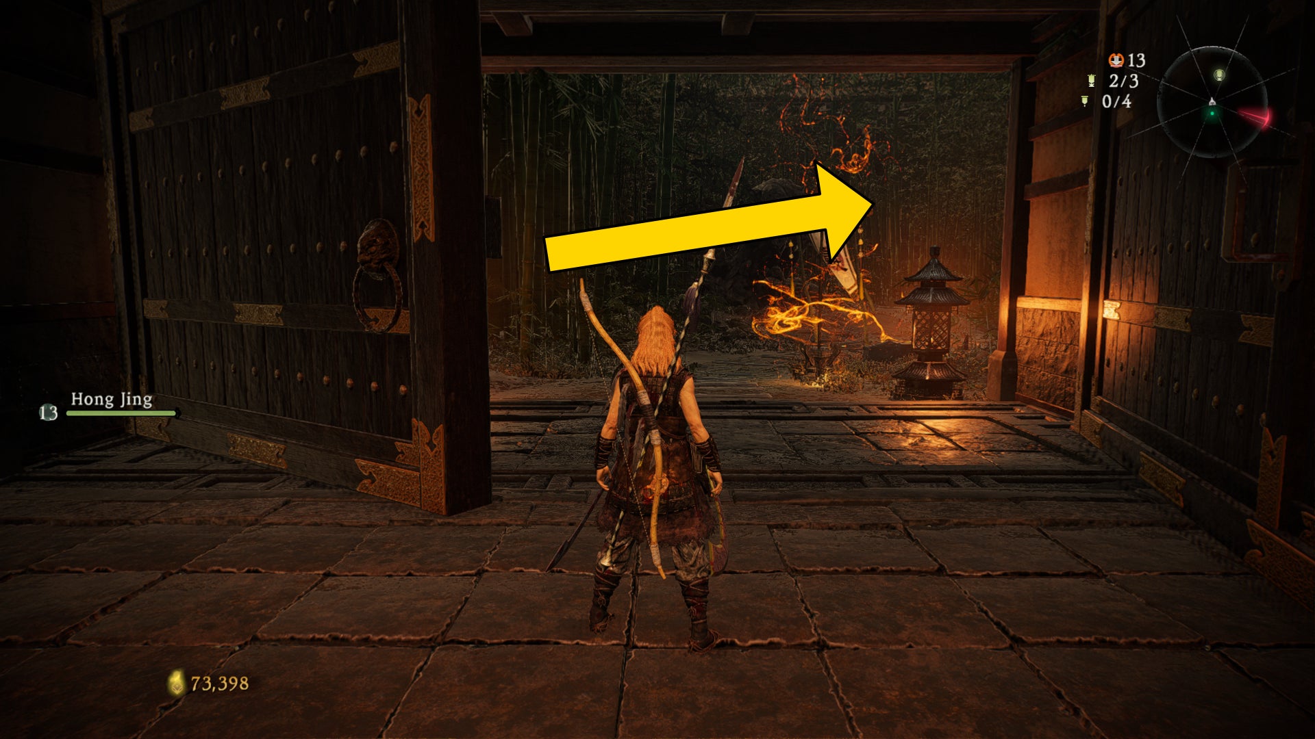 El jugador de Wo Long se para frente a una puerta, detrás de la cual hay una bandera de batalla.  Una flecha indica la ubicación del Shitieshou más cercano.